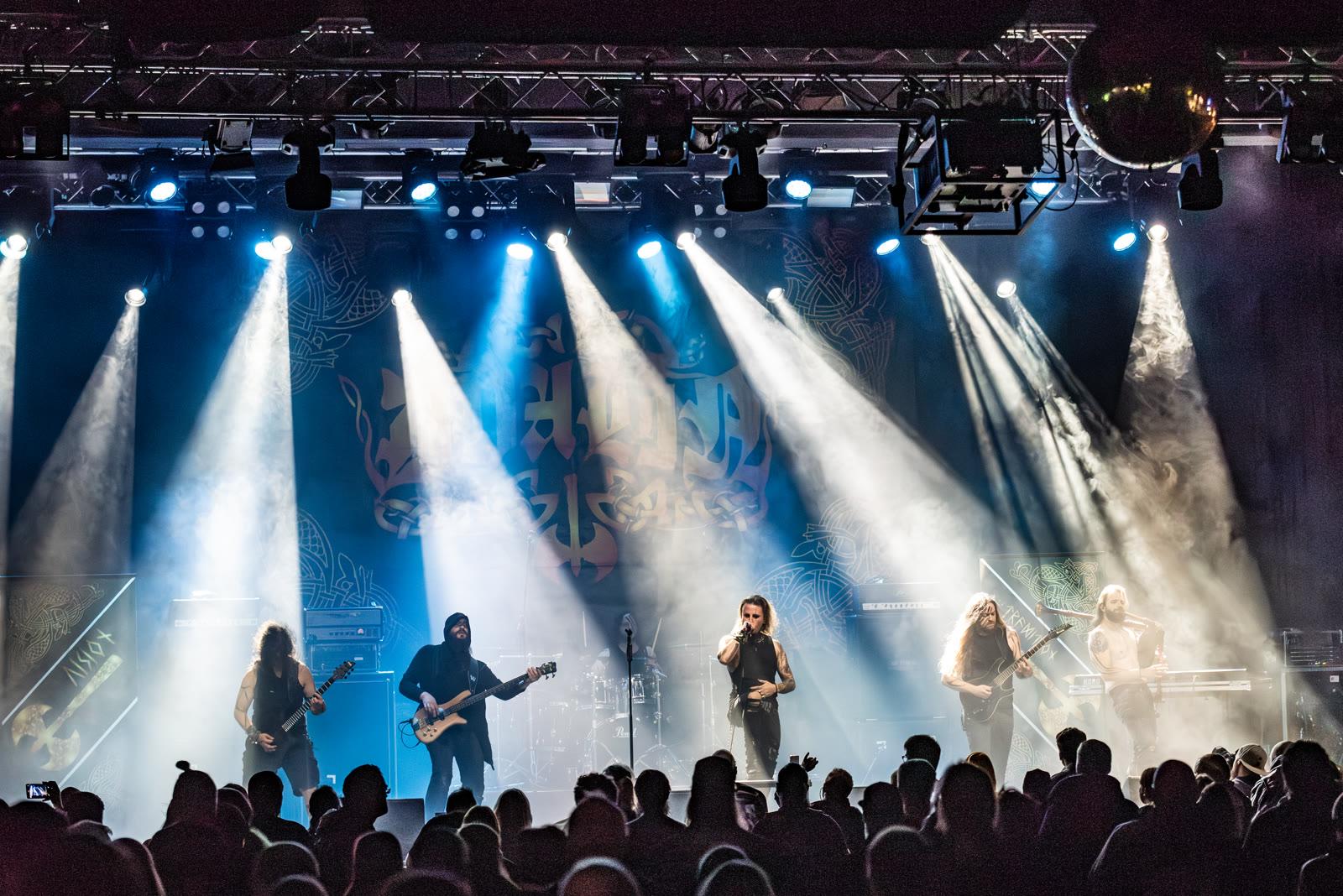 Dvalin live on stage, blue spotlights and haze above the crowd