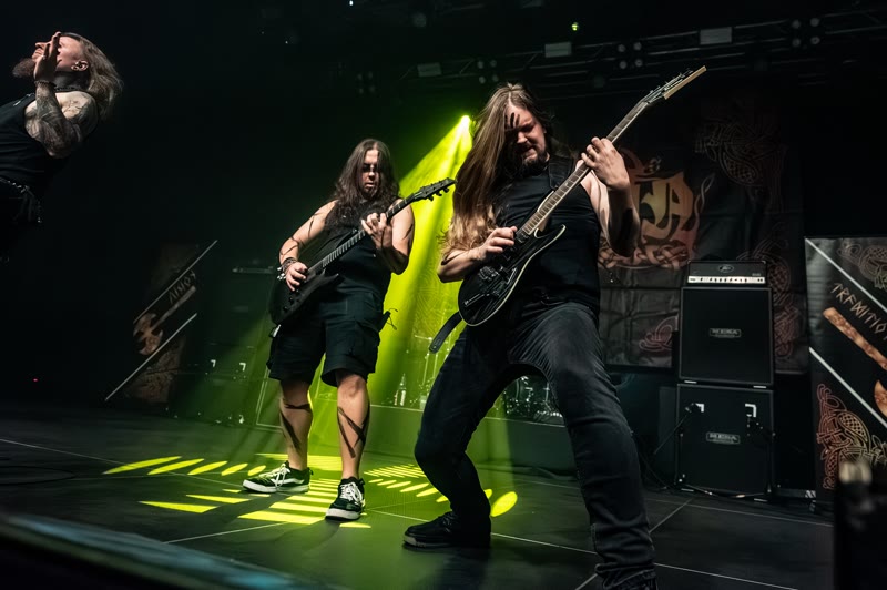 Thomas and Riese on guitars, bathed in green light