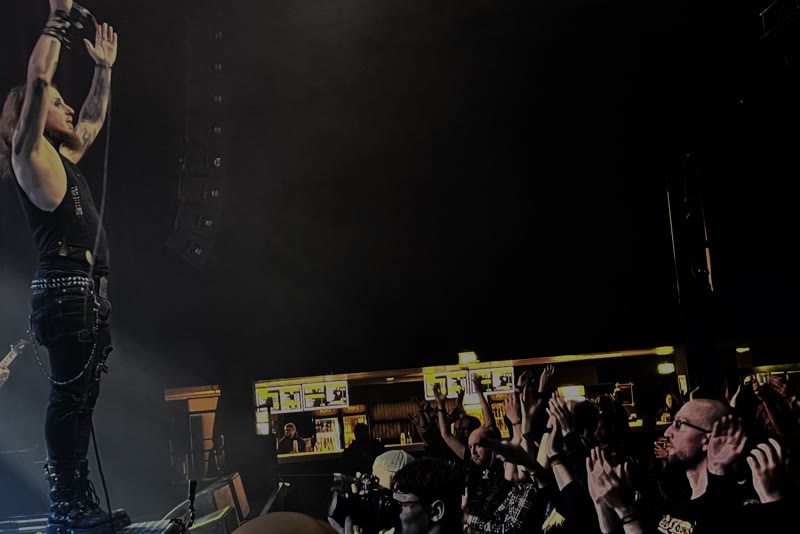 View from the stage into the audience, many raised hands